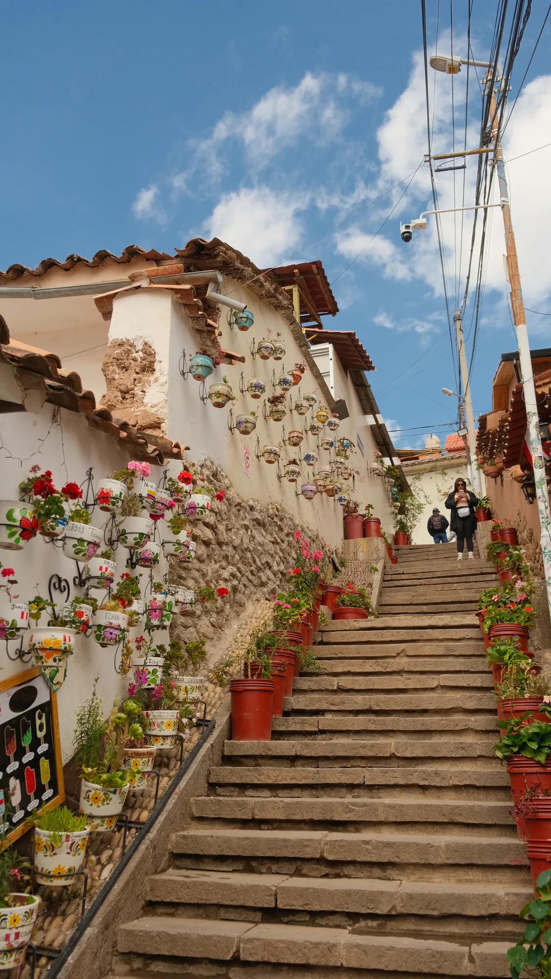 A wide view over Cusco from a hillside overlook, mountains rising behind the city.