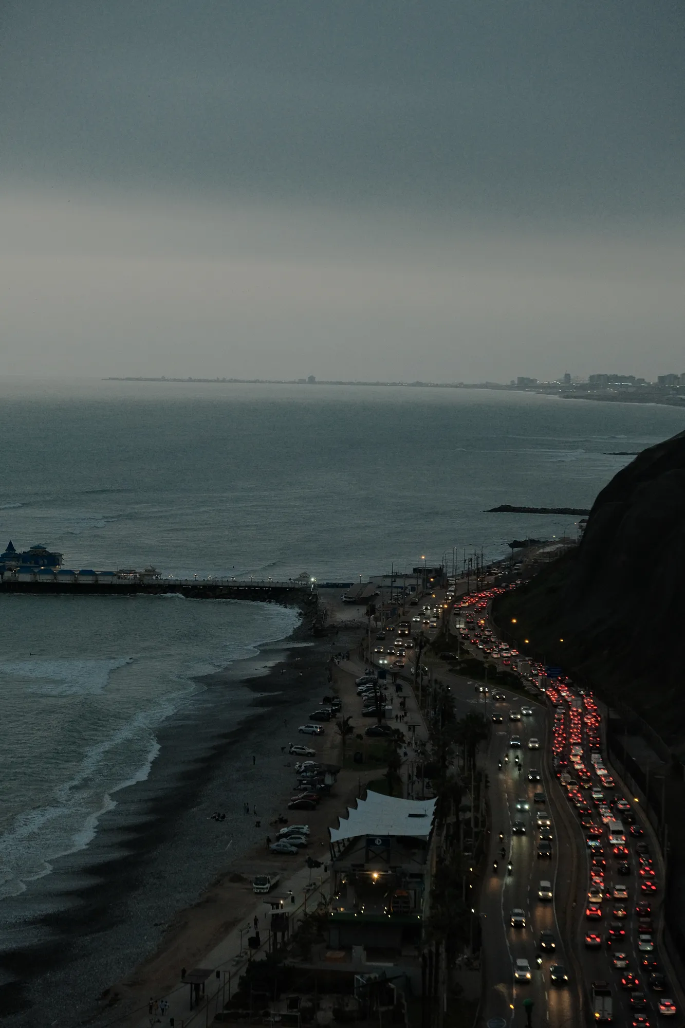 Afterglow over the Pacific off Lima, the sky fading from orange to deep blue.