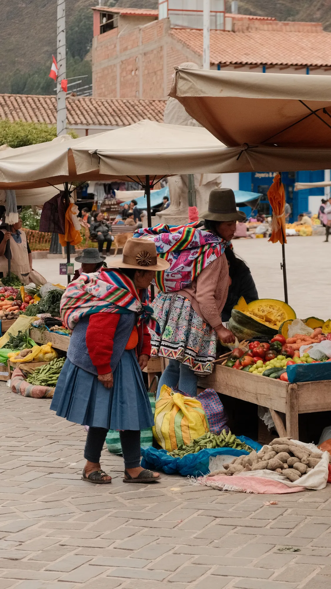 A crowd gathers in Pisac's plaza for a wedding celebration, confetti scattered underfoot.