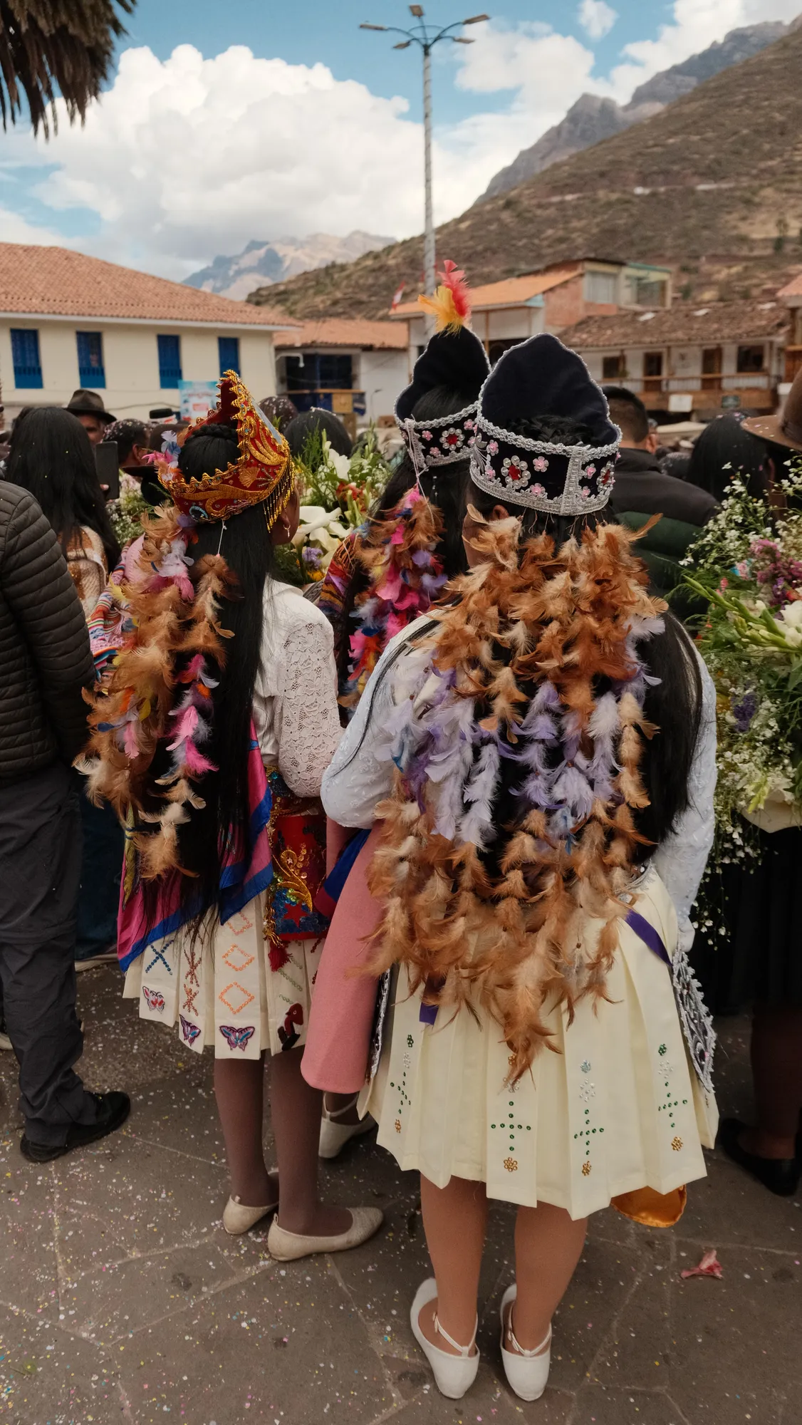 Guests in Pisac's plaza during a wedding celebration, flowers and confetti scattered about.