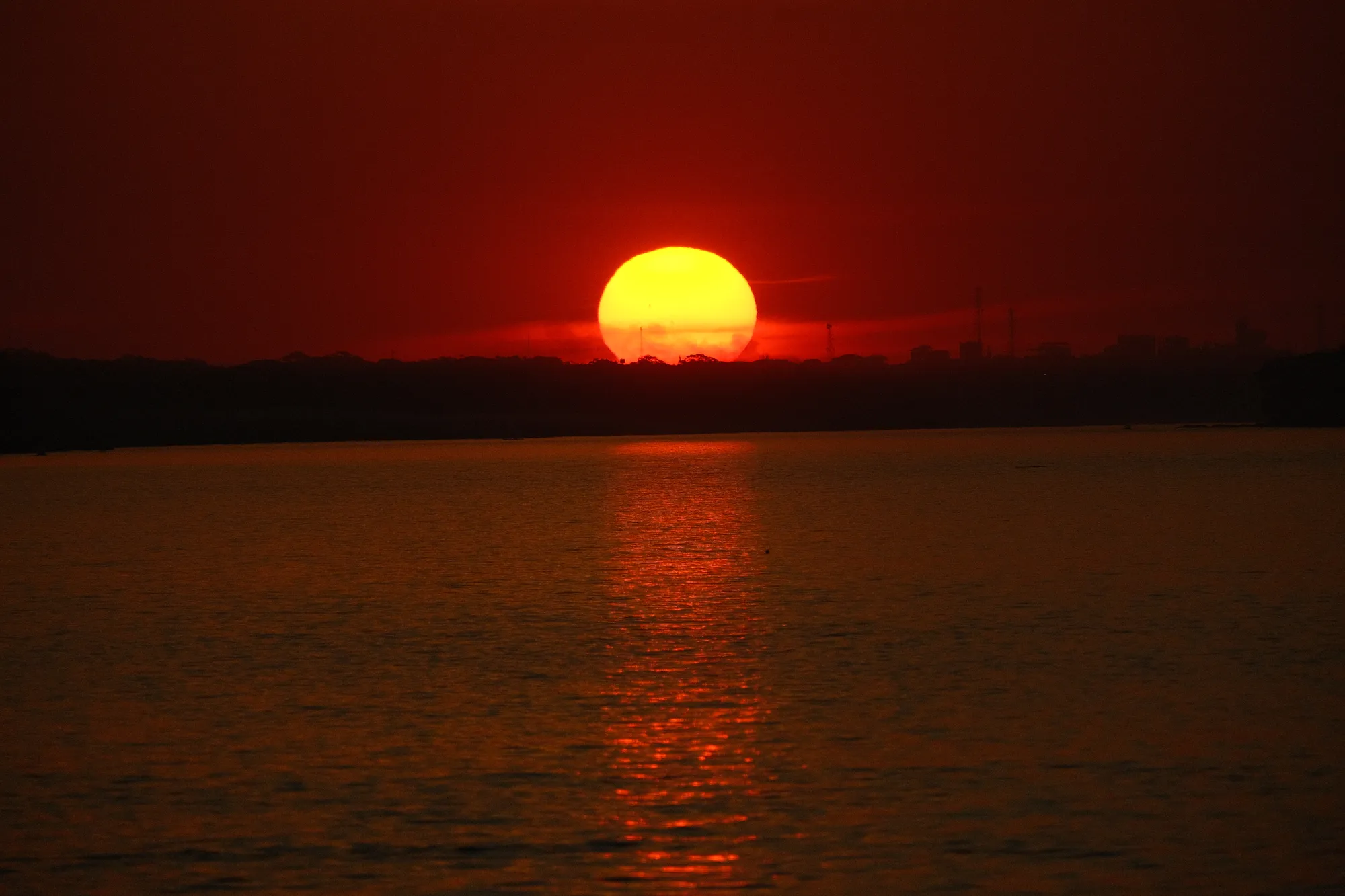 The river reflects the evening sky near Puerto Maldonado, rainforest along both banks.