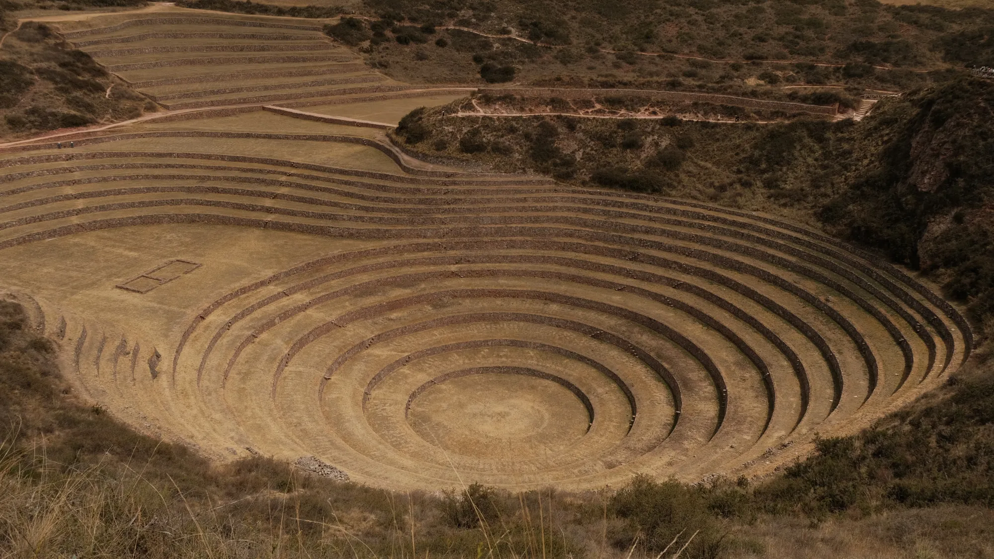 The circular Inca terraces of Moray, concentric rings cut into a natural depression in the earth, used to test crops at different microclimates.