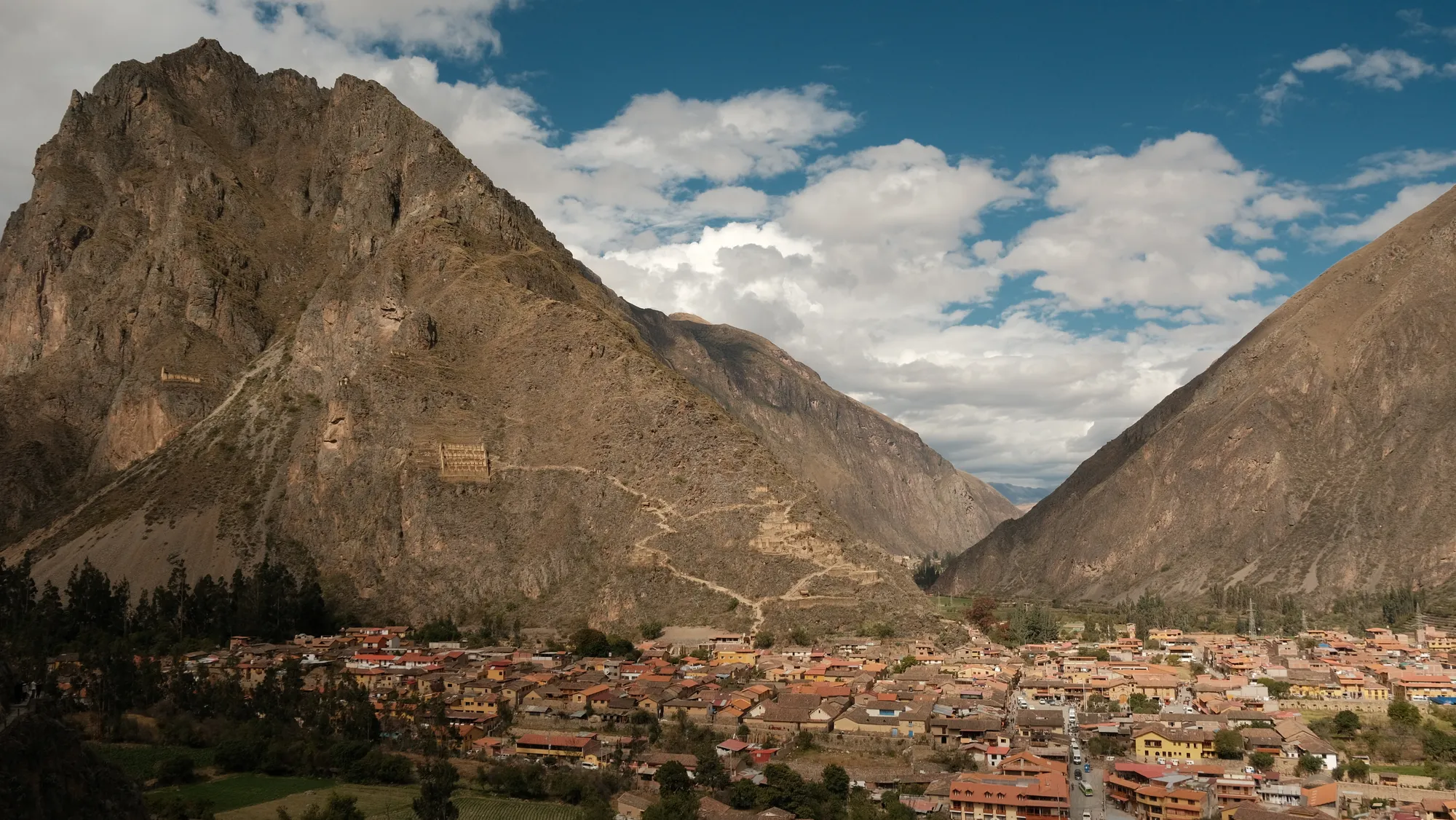 The Sacred Valley opens out below, fields and scattered houses in the afternoon light, approaching Ollantaytambo.